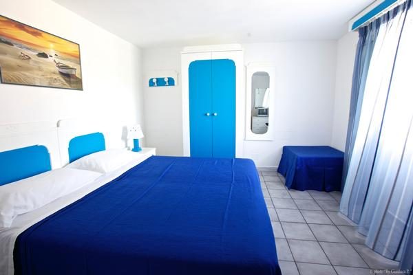 Camera con copriletto blu — Oasi B&B Ponza